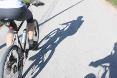 Shadow of person riding bicycle on street