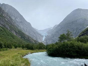 Scenic view of river amidst mountains against sky