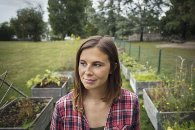 Thoughtful mid adult woman in vegetable garden