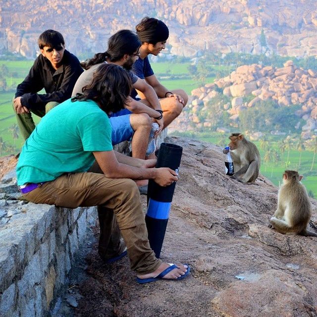 lifestyles, animal themes, togetherness, leisure activity, casual clothing, full length, bonding, men, sitting, boys, mammal, love, domestic animals, person, friendship, day, rear view