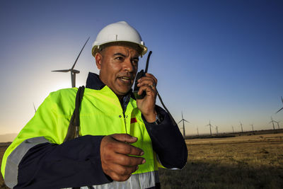 Technician using walkie-talkie on a wind farm