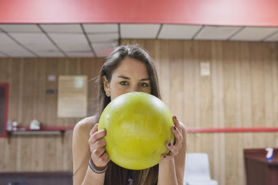 A young woman with a yellow bowling ball.