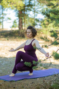 Young woman exercising on field