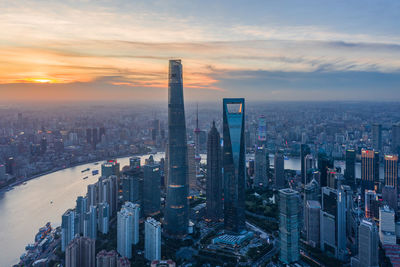 Aerial view of modern buildings against sky during sunset