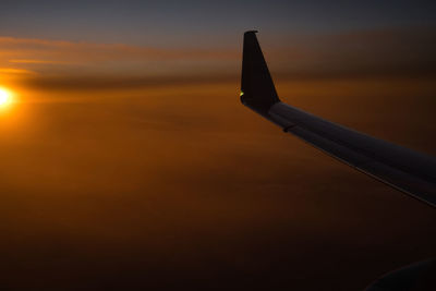 Airplane flying in sky during sunset