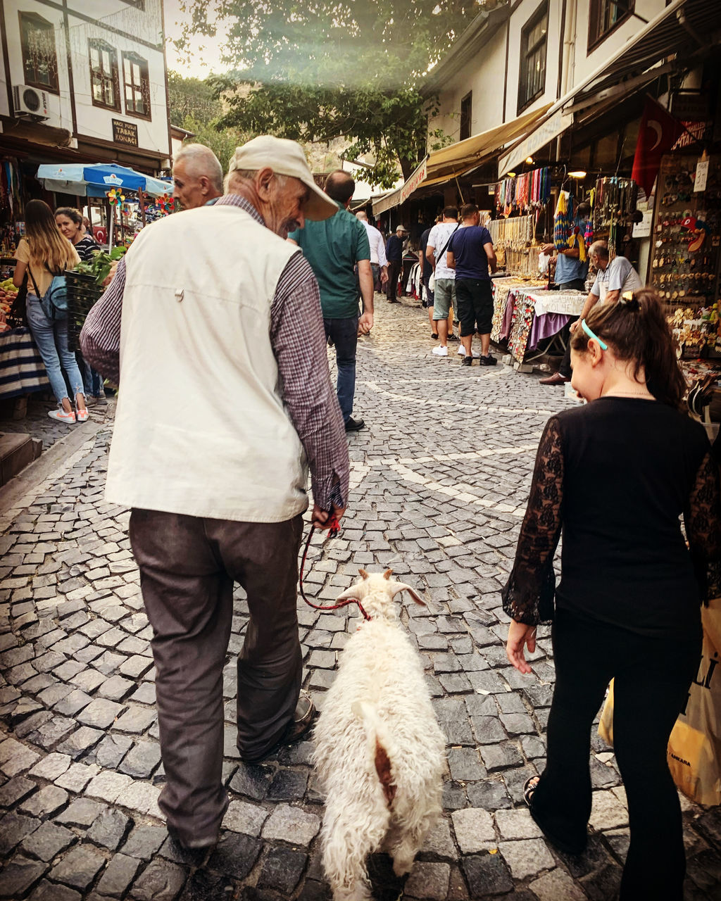 REAR VIEW OF PEOPLE WALKING ON STREET