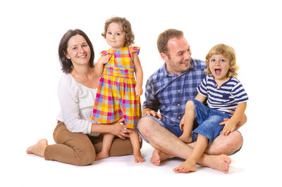 Portrait of two people sitting against white background