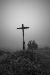 Cross on field against clear sky