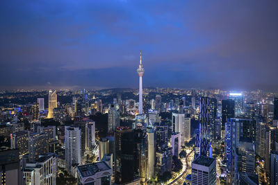 Illuminated buildings in city against sky at night