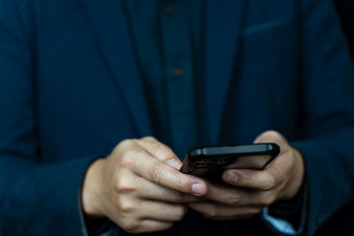 Midsection of man using mobile phone