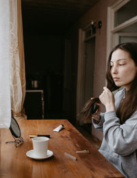 Young woman using mobile phone while sitting at home