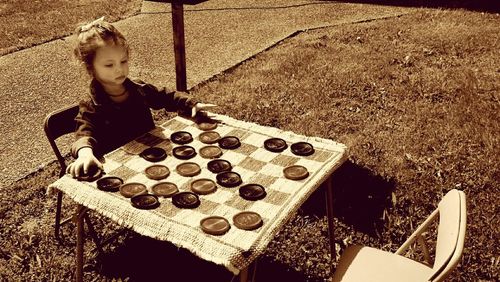 High angle view of boy playing on chess board