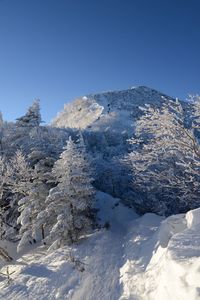 Scenic view of snowcapped mountains against clear blue sky