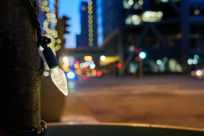 Close-up of illuminated lighting equipment on street at night