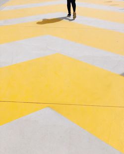 Low section of man walking on zebra crossing