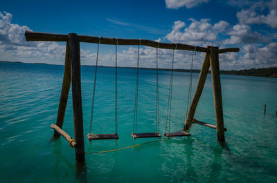 Swimming pool by sea against sky