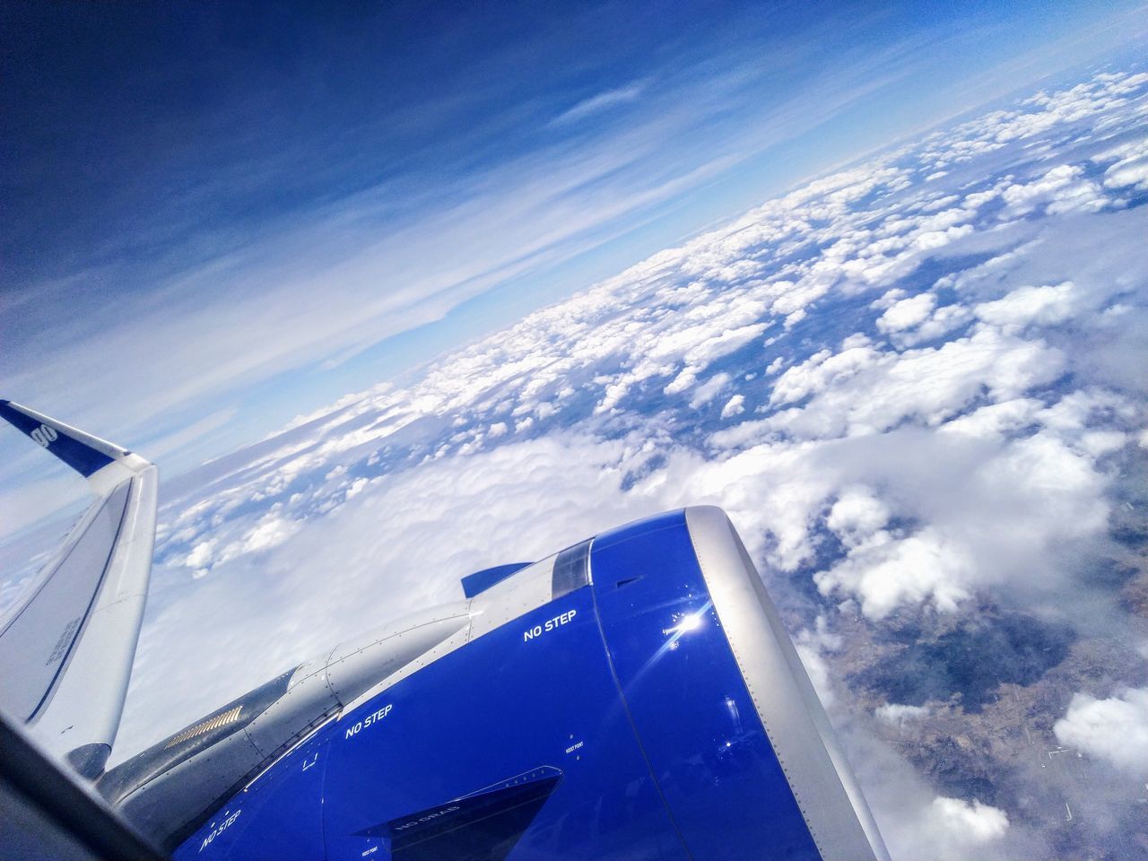 AERIAL VIEW OF AIRCRAFT WING OVER CLOUDS