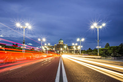 Light trails on street against sky at night