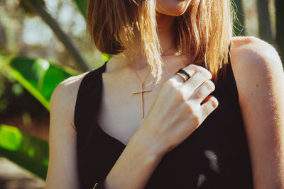 Midsection of woman holding smart phone outdoors