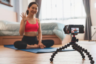 Woman photographing with mobile phone at home