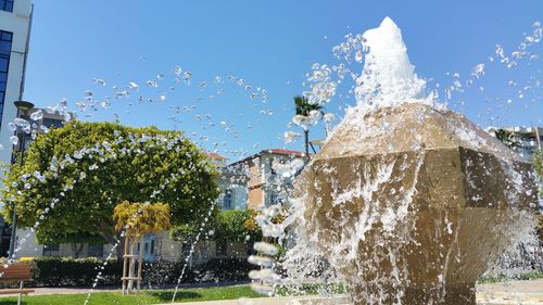 Water splashing on fountain against trees