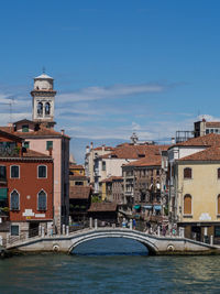 Bridge over sea against buildings in city