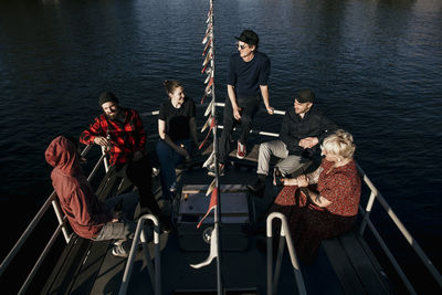 Friends spending leisure time together sitting on boat deck