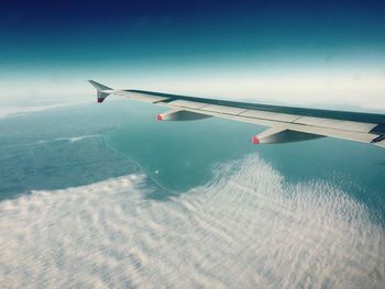 Cropped image of airplane wing over landscape