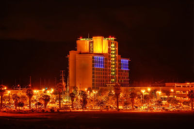 Illuminated buildings against sky at night