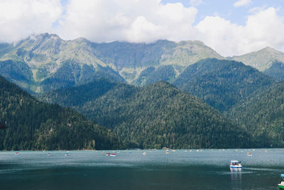 Scenic view of lake by mountains against sky