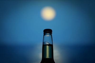 Close-up of glass bottle against blue background