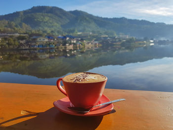 Close-up of coffee on table against mountains