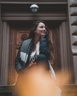 Low angle view of thoughtful young woman looking away