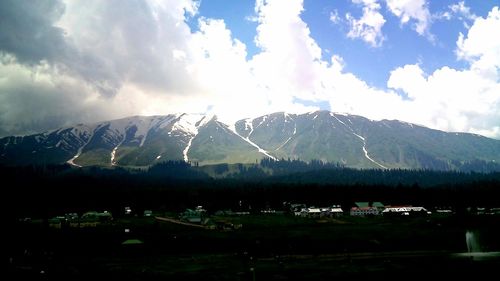 Panoramic view of illuminated mountains against sky
