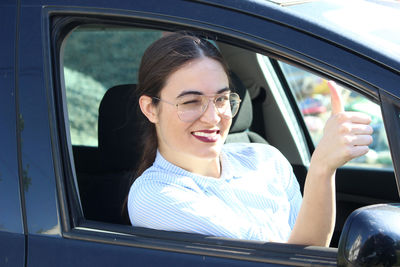 Portrait of smiling woman sitting in car