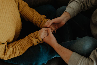 Midsection of couple holding hands