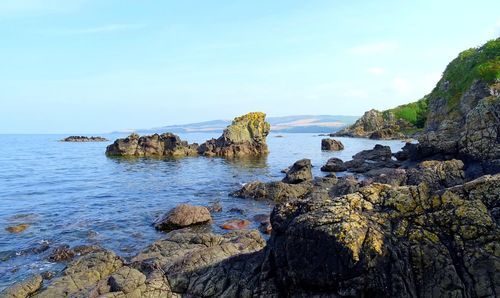 Scenic view of rocks on beach against sky