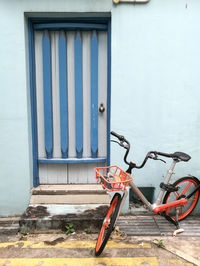 Bicycle parked against wall of building