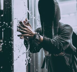 Man splashing water by window