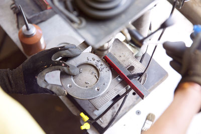 Cropped image of manual worker drilling metal at workshop