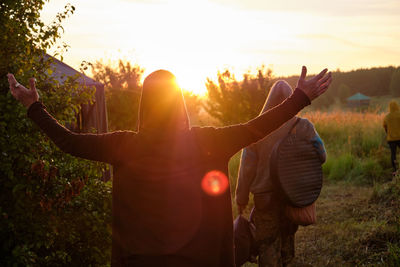 Dawn. the man stretched out his hands towards the sun, viewed from the back. nature, summer.