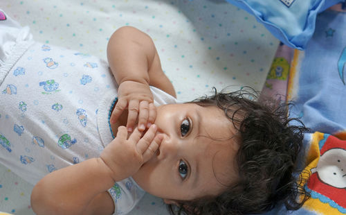 Portrait of baby lying on bed