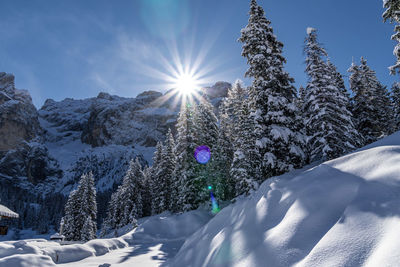 Scenic view of snow covered mountains against bright sun