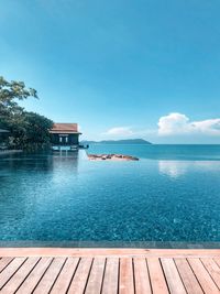 Swimming pool by sea against sky