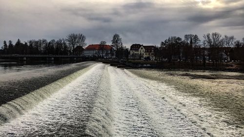 Road amidst houses against sky