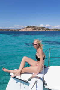 Full length of woman sitting on boat in sea against sky