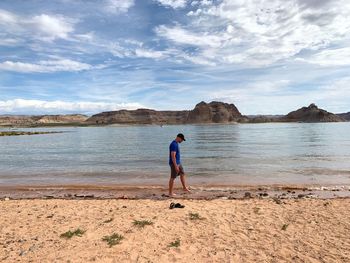 Full length of man standing on beach against sky