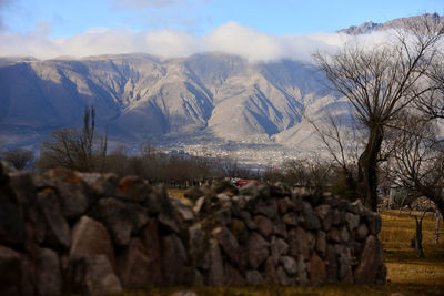 Stone wall on field with mountains in background