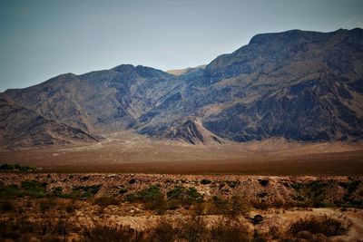 Scenic view of land and mountains against sky