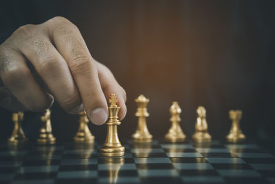 Cropped hand of man playing chess